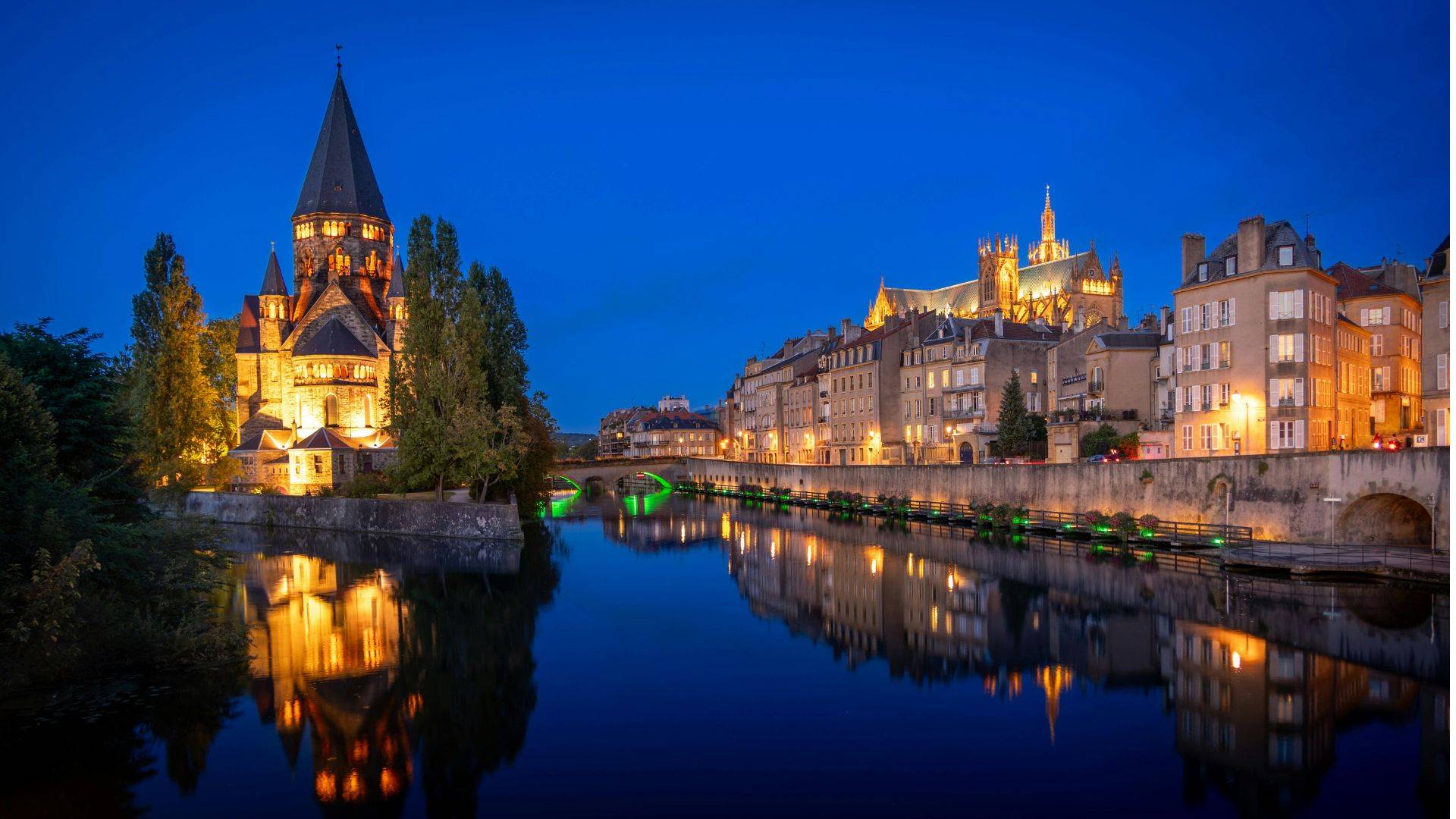 La cathédrale Saint-Étienne et le Temple Neuf de Metz reflétés dans la Moselle à la tombée de la nuit
